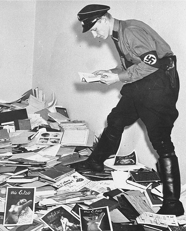 Hirschfeld Institute library burning. Nazi reading before